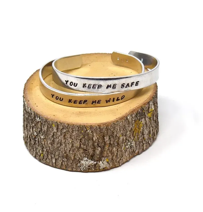 Molly's friendship cuffs that read You keep me safe and You keep me wild